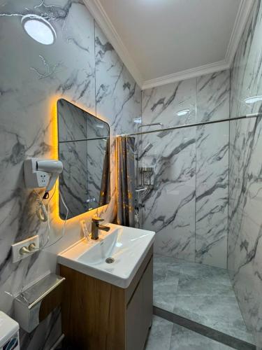 a bathroom with a sink and a mirror at Uya Nest Osh in Osh