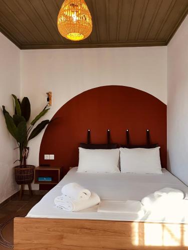 a bedroom with a large white bed with a wooden headboard at Skapin house in Skopelos Town