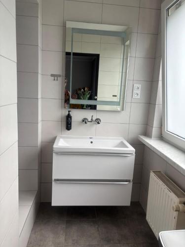a white bathroom with a sink and a mirror at 208 Apartment Ania in Koszalin