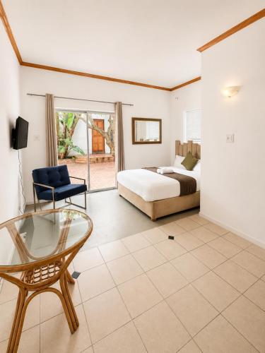a bedroom with a bed and a glass table at 12 On Braemar Guesthouse in Cape Town