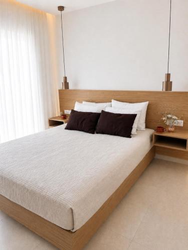 a bedroom with a large bed with two pillows at Oikos Apartments in Haraki