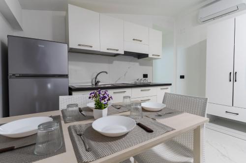 a kitchen with a table with white plates on it at Marechiaro Aparthotel in Marina di Camerota