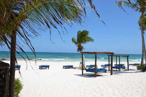 una spiaggia con un mucchio di sedie e l'oceano di Stay in Tulum! a Tulum