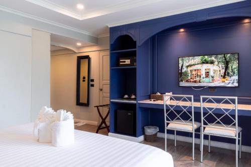 a bedroom with a blue wall with a tv on it at Rimwiang in Chiang Mai