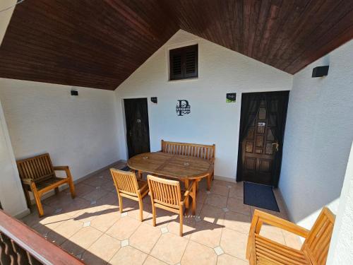 a patio with a wooden table and chairs and a door at Ferienwohnung Prestele in Risika