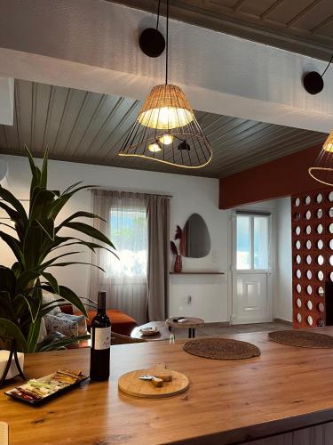 a living room with a table with a bottle of wine at Skapin house in Skopelos Town