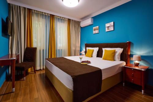 a bedroom with a large bed with blue walls at Art Green Boutique Hotel in Varna City