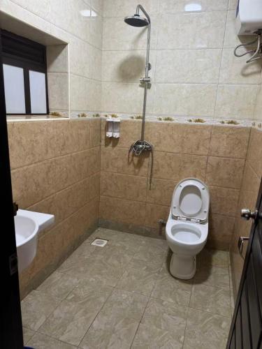a bathroom with a toilet and a sink at Kibuli beijing hotel in Kampala