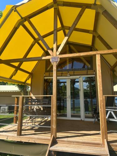 a wooden deck with an umbrella on a house at Glamping Camping Rivabella in Lecco