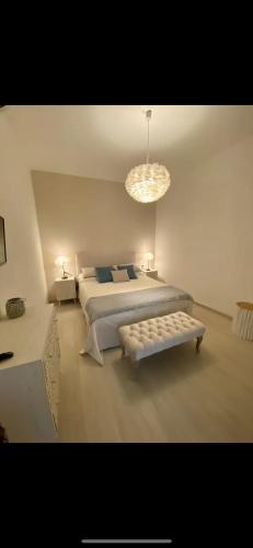 a white bedroom with two beds and a chandelier at Stella di Mare with Jacuzzi, Costa Smeralda in Arzachena