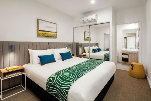 a bedroom with a large bed with blue pillows at Quest Griffith in Griffith