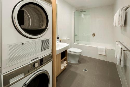 a bathroom with a washer and dryer in it at Quest Griffith in Griffith