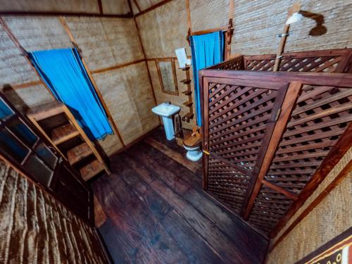 an overhead view of a bathroom with a toilet and blue curtains at Pemba Eco Lodge in Kengeja