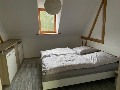 a small bedroom with a bed and a window at Waldblick in Neresheim