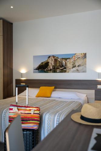 a hotel room with a bed with a hat on it at Firmafede Guest House in Sarzana