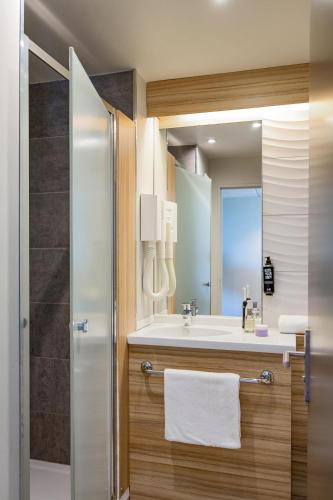 a bathroom with a sink and a mirror at Ibis Clermont-Ferrand Centre Stade in Clermont-Ferrand