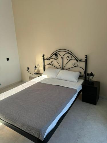 a bedroom with a large bed with a metal headboard at Ontas in Tholária