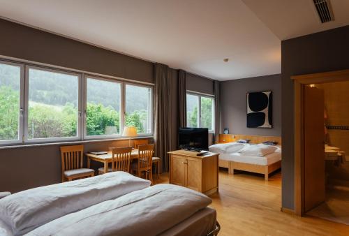a bedroom with two beds and a desk and a table at Lodenwirt Residence in Vandoies