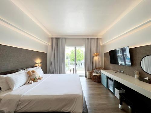 a hotel room with a large bed and a television at Veranda Resort & Villas Hua Hin Cha Am in Cha Am