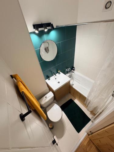 a bathroom with a white toilet and a sink at Pine Apartment, Riga in Riga