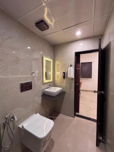 a bathroom with a toilet and a sink and a shower at Raghuwar Palace in Ayodhya