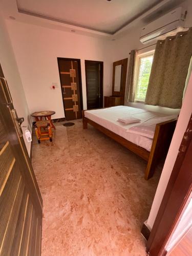 a bedroom with a bed and a window at Jonaki Shantiniketan in Shānti Niketan