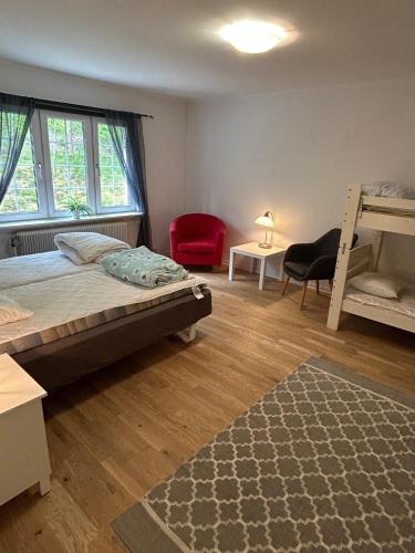 ein Schlafzimmer mit einem Bett und einem roten Stuhl in der Unterkunft Kloster Gård - Cabins & apartments near Astrid Lindgrens World in Hultsfred