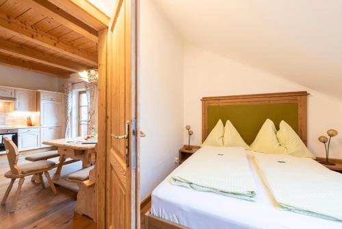 a bedroom with a bed and a table in a room at Kinderparadies Bachbauer in Mondsee