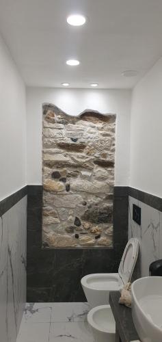 a bathroom with two toilets and a painting on the wall at Maréa suite con giardino in Marina di Carrara