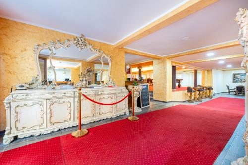 a room with a red carpet and a vanity with a mirror at Hotel Perun in Budva