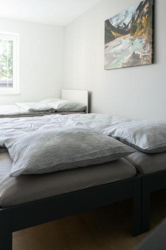 a bed in a bedroom with a picture on the wall at Apartmán nad pilou in Velké Meziříčí