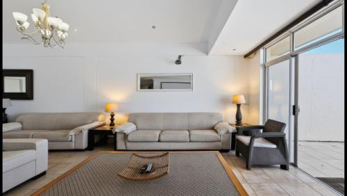 a living room with two couches and a table at Santorini 402B in Margate