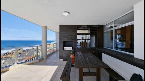 a living room with a bench and a view of the ocean at Santorini 402B in Margate