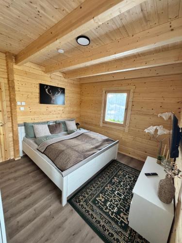 a bedroom with a bed in a wooden cabin at Modernes Blockhaus mit Sauna Flair in Lisberg