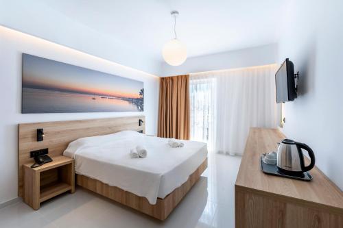 a hotel room with a bed and a television at Zorbas Beach Hotel in Tigaki