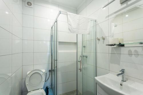 a bathroom with a shower and a toilet and a sink at Ośrodek Wypoczynkowy AS PIK dawniej Hotel AS PIK in Niechorze