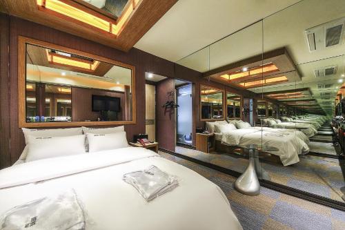 a bedroom with four beds and a large mirror at 부평 호텔 루와 in Pup'yŏng-yŏk