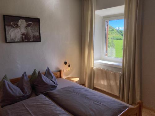 a bedroom with a bed with a cow picture on the wall at Sallrain Hof Apartment 2 in Collalbo
