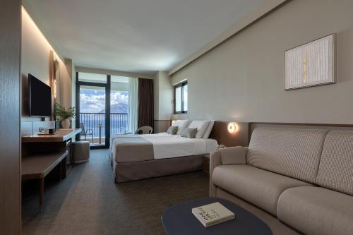 a hotel room with a bed and a couch at Airotel Achaia Beach in Patra