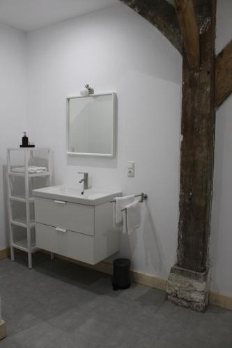 a white bathroom with a sink and a mirror at Biohof Holthusen in Hammelwarder Außendeich