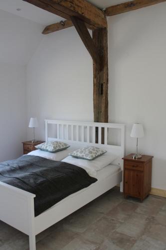 a bedroom with two white beds and two night stands at Biohof Holthusen in Hammelwarder Außendeich