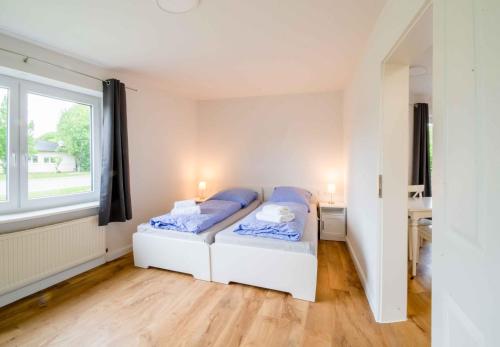 a bedroom with two beds and a window at Schleiblick App 14 in Rabenkirchen-Faulück