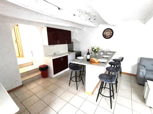 a kitchen with a counter and stools in a room at Gîte ô scope-2km du futuroscope- linges et ménage inclus in Jaunay-Clan