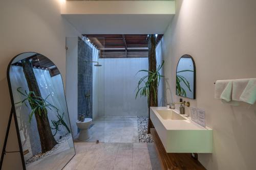 a bathroom with a sink and a shower and a toilet at Sealuna Villas in Tanah Lot