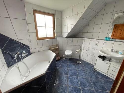 a bathroom with a tub and a sink at Ferienwohnung Ahrtalfreude in Sinzig
