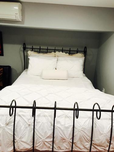 a bed with a black frame and white sheets and pillows at Studio H St Corridor in Washington, D.C.