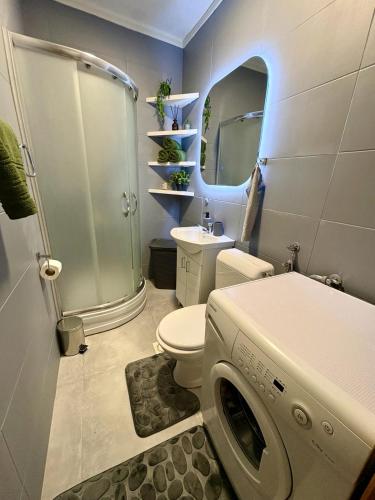 a bathroom with a toilet and a shower and a washing machine at SkyLux Premium Zenica in Zenica