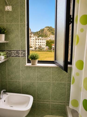 a bathroom with a sink and a window at Berat Skyline Apartment in Berat
