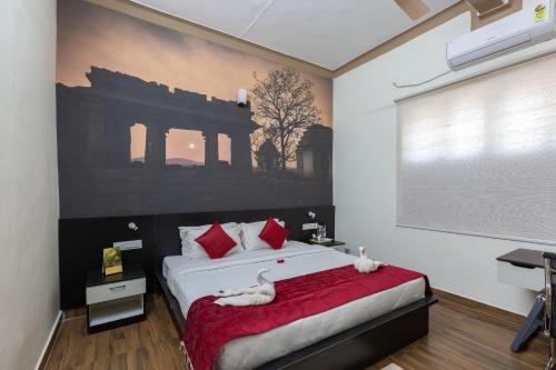 a bedroom with a bed with two cats on it at KSTDC Hotel Mayura Vijayanagara Hampi in Hospet