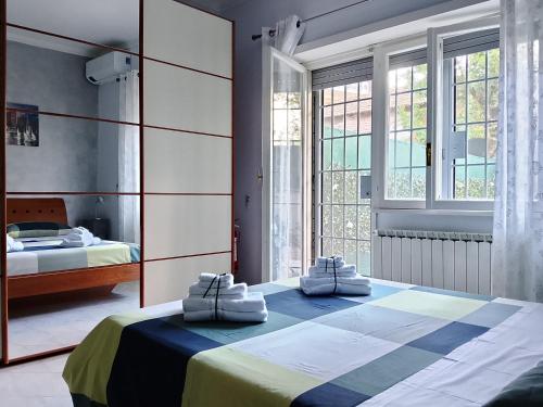 a bedroom with two beds and a large window at Casa Melo in Ciampino